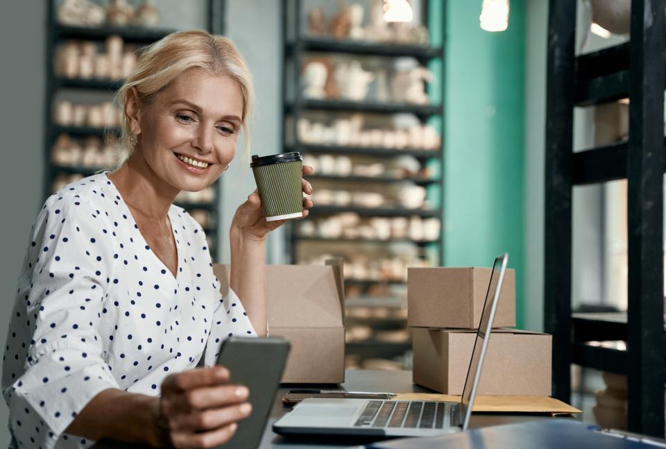 Firmeninhaberin betrachtet ihren gerade geschickten Newsletter an wenige Kunden auf dem Handy.