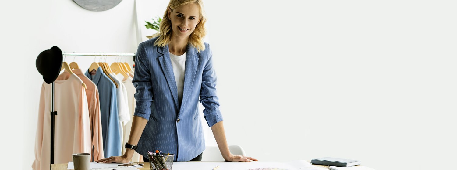 Frau, die glücklich vor Ihrem Schreibtisch steht.