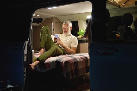 Mann, der im Wohnwagen am Tabet arbeitet.