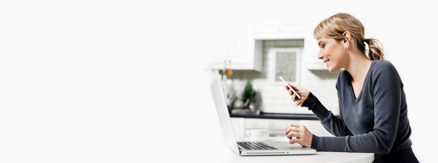 Frau vor Notebook wird von unserer Spezialisten Hotline auf ihrem Telefon zurückgerufen.