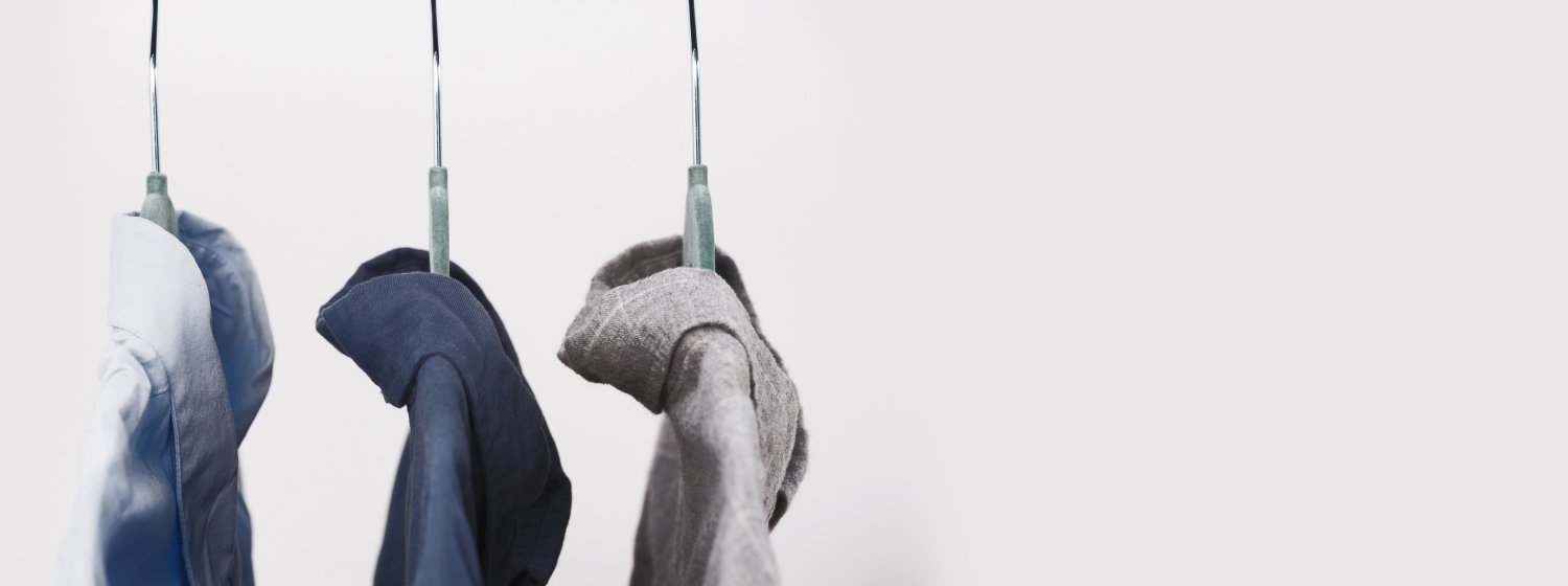 Drei Kleiderbügel mit verschiedenfarbigen Hemden.