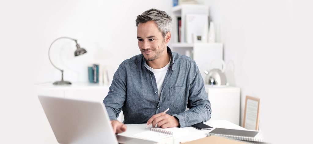 Shopbetreiber vor Computer freut sich, dass die PDF-Rechnungen jetzt automatisiert erstellt werden.