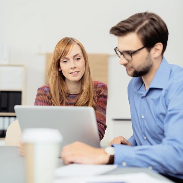 Agentur-Mitarbeiter erklärt seinem Kunden am Rechner, wie einfach die Bedienung des SIQUANDO Pro Agentur-Client ist.